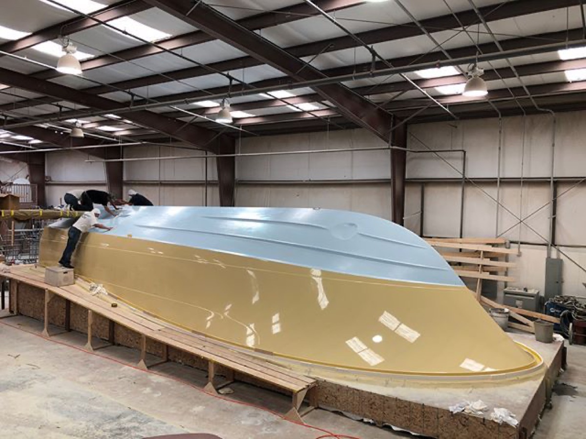 A custom boat hull taking shape in the mold on the shop floor